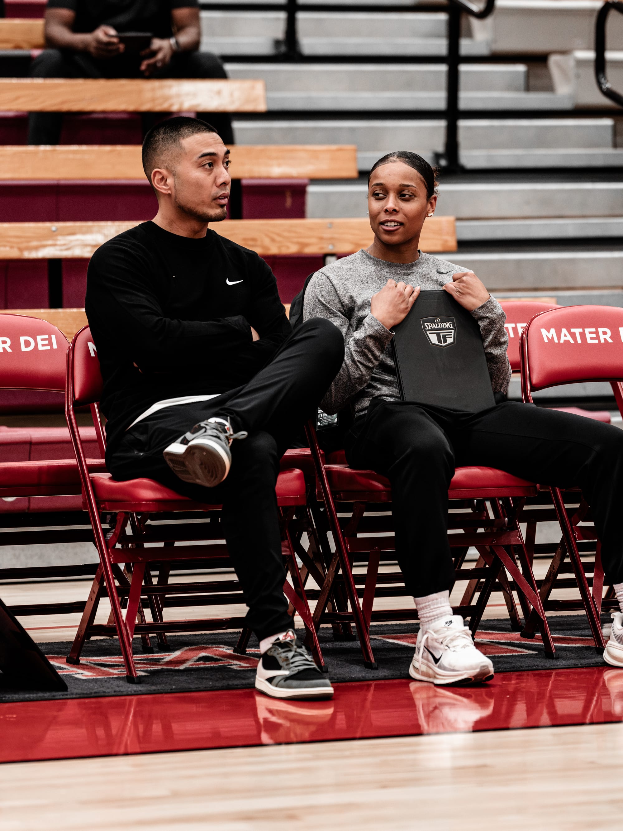 Coach Josh and Coach Asia courtside in conversation with a play board